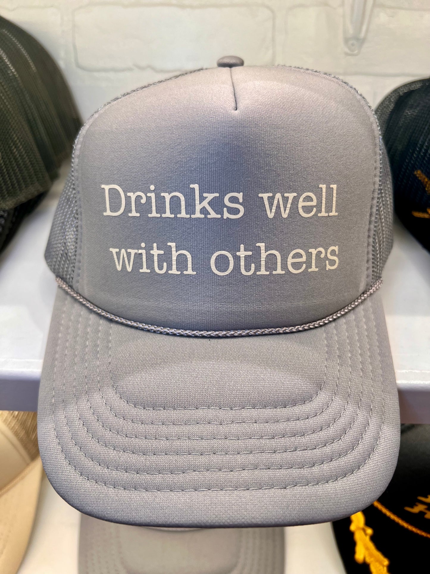 Drinks well with others Trucker Hat